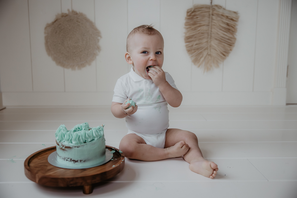 Cakesmash  met bohemian achtergrond. Baby jongen viert zijn 1e verjaardag met een groene naked cake met slagroomtoefjes. Cakesmashshoot door fotograaf Nickie Fotografie uit Dokkum, Friesland.