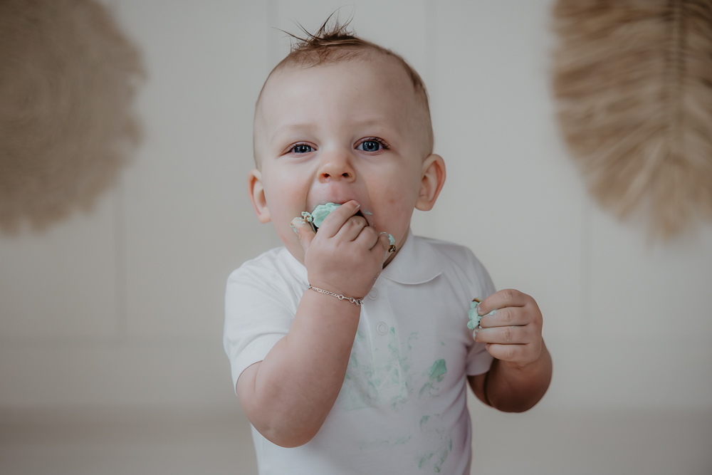 Cakesmash Dokkum. 1 jarige dreumes eet de taart met zijn handen. Fotoreportage door fotograaf Nickie Fotografie uit Friesland.