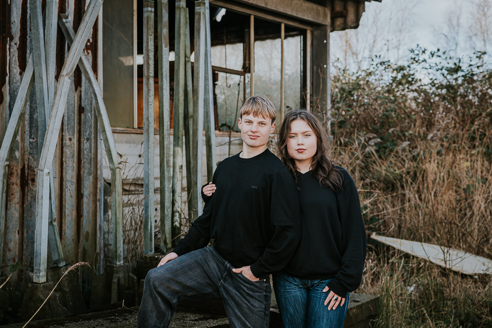 Industrieel gezinsshoot. Portret van broer en zus bij oude en verlaten fabriek in Dokkum, Friesland. Fotoreportage door fotograaf Nickie Fotografie.