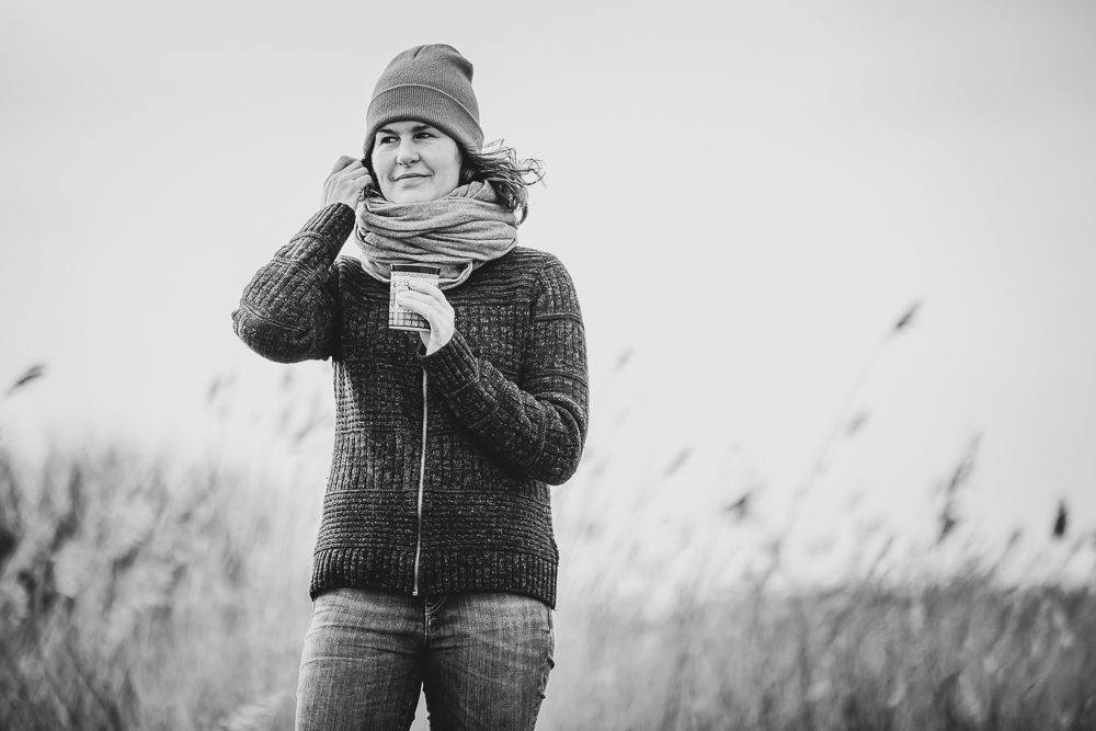 Fotograaf Friesland. Zwartwit winters portret met warme chocolademelk gevoel doordat deze vrouw een warme trui met muts en dikke sjaal draagt. Fotoshoot door fotograaf Nickie Fotografie uit Dokkum.