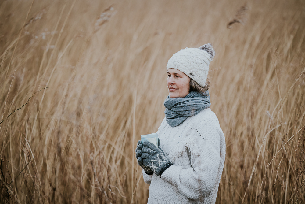 Wintershoot bij het Lauwersmeergebied. Portret van dame warm gekleed in dikke wollen trui met muts, handschoenen en warme sjaal. Fotosessie door fotograaf Nickie Fotografie.