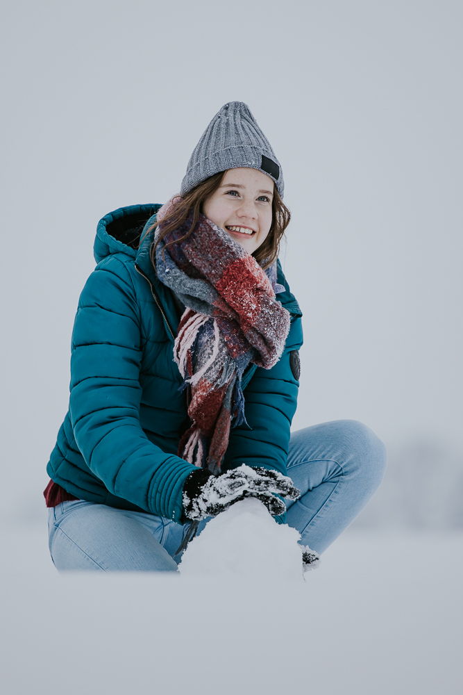 Winterfotografie. Meisje speelt in de sneeuw. Fotosessie door fotograaf Nickie Fotografie uit Dokkum, Friesland.