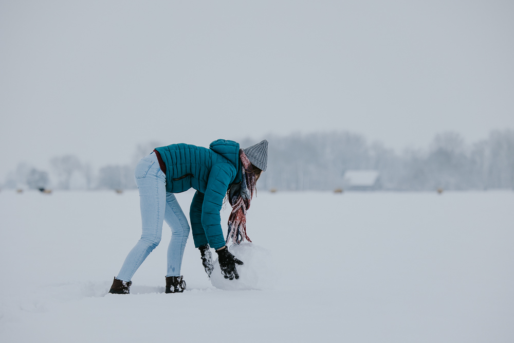 Speelse winterreportage. Meisje maakt een sneeuwpop. Fotoreportage door fotograaf Nickie Fotografie uit Dokkum, Friesland.