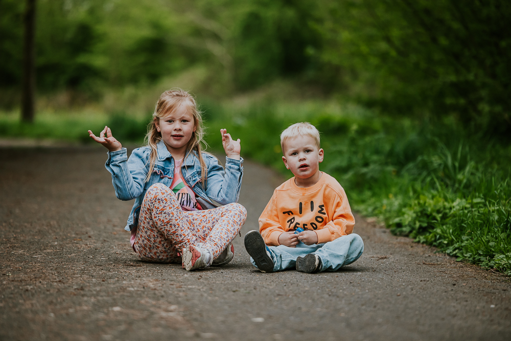 Fotoshoot Friesland. Portret van zittende broer en zus in het park door fotograaf Nickie Fotografie uit Dokkum.
