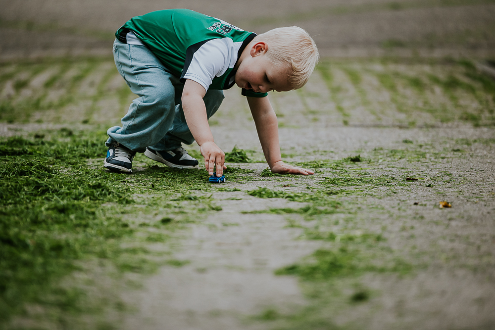 Jongetje is aan het spelen met zijn blauwe autootje. Fotoreportage door fotograaf Nickie Fotografie.