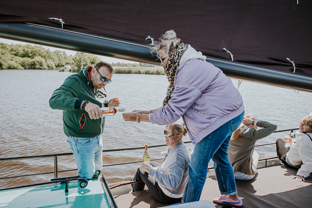 Een wijntje inschenken tijdens de zeiltocht op een skutsje. Fotoreportage door fotograaf Nickie Fotografie uit Friesland.
