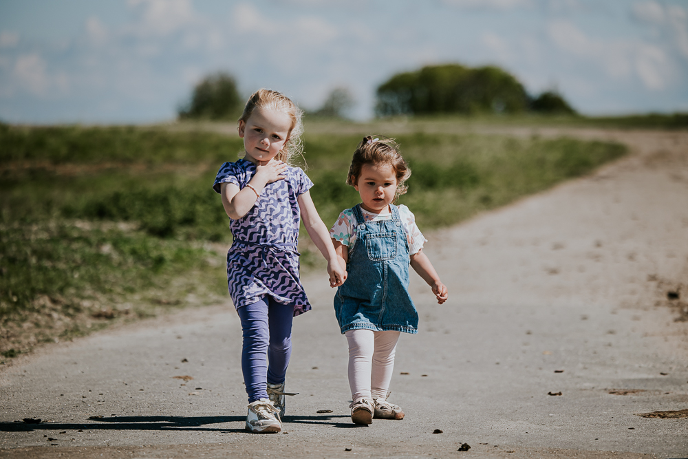 Fotograaf Friesland. Hand in hand lopen de twee nichtjes in het kweldergebied bij Peasens-Moddergat. Fotoreportage door Nickie Fotografie.