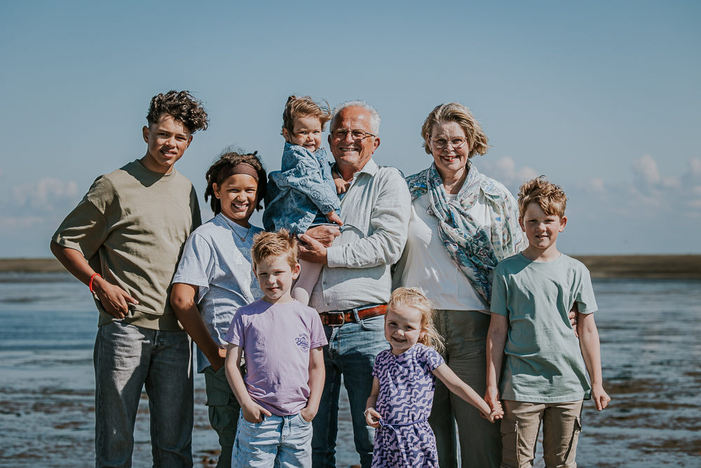 Familieshoot bij de zeedijk. Portret van de grootouders met hun kleinkinderen bij de Waddenzee door fotograaf Nickie Fotografie uit Friesland.