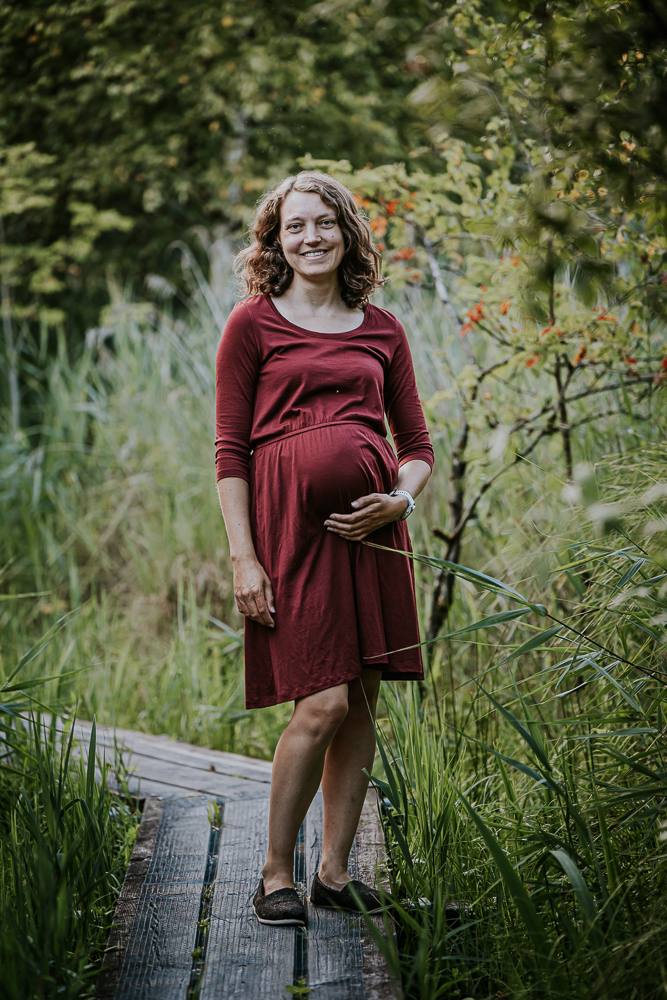 Zwangerschapsshoot in De Deelen. Portret van aanstaande moeder op de houten vlonderpad, door bolle buik fotograaf Nickie Fotografie uit Friesland.