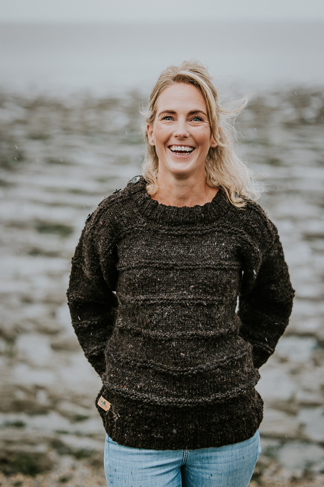 Bedrijfsfotografie Friesland. Model in warme wollen trui bij het Wad. Fotoshoot door bedrijfsfotograaf Nickie Fotografie.