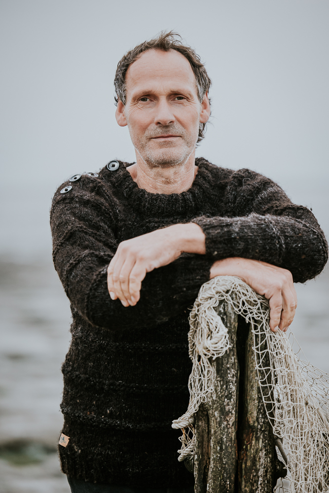 Bedrijfsfotograaf Nickie Fotografie. Man staat met zijn visnet bij de Waddenzee.