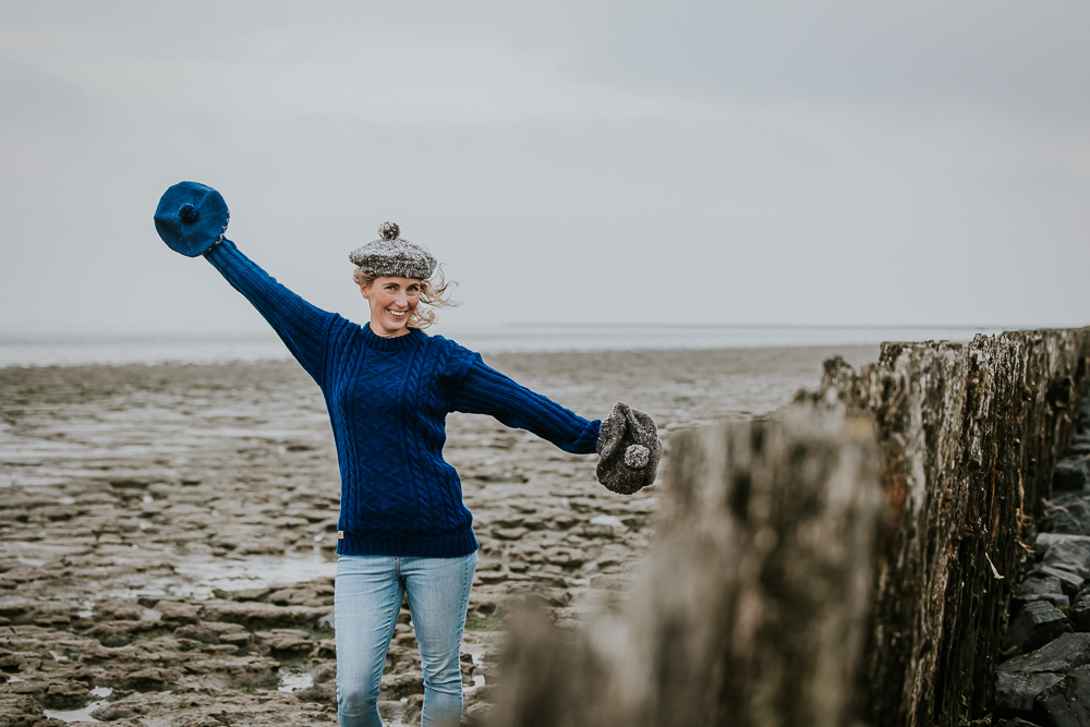 Model met drie wollen mutsen bij de Waddenzee. Bedrijfsshoot door fotograaf Nickie Fotografie uit Dokkum, Friesland.