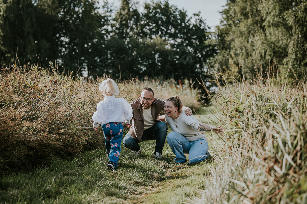 Gezinsshoot Earnewâld. De dochter komt er aan rennen. Lifestyle gezinsfotografie door fotograaf Nickie Fotografie uit Friesland.