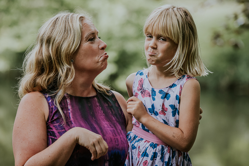 Fotoshoot in Park Vijversburg door fotograaf Nickie Fotografie. Grappig portret van moeder en dochter die gekke bekken trekken.