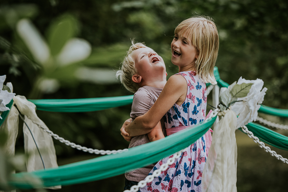 Fotoshoot Friesland door fotograaf Nickie Fotografie. Broer en zus geven elkaar een dikke knuffel op een versierde brug in het park der fabelen van Vijversburg in Tytsjerk.