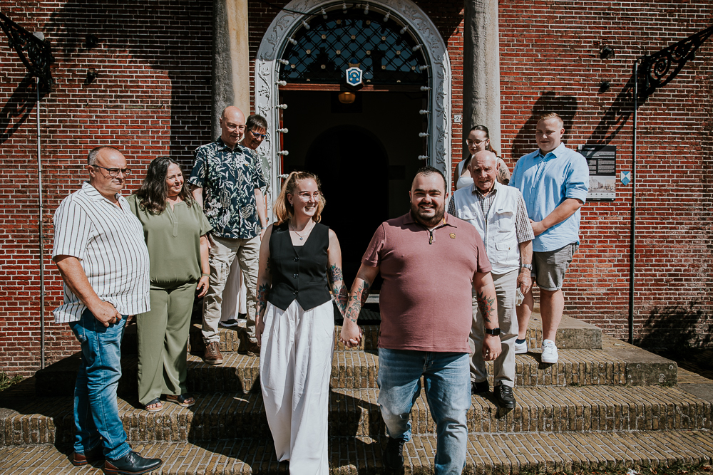 Geregistreerd partnerschap Dokkum door fotograaf Nickie Fotografie uit Friesland. Het bruidspaar loopt door de erehaag gemaakt door de familie.