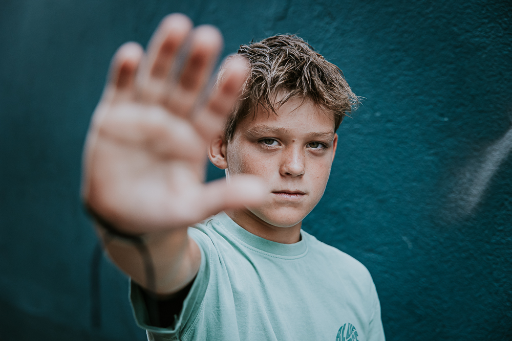 Tienershoot Dokkum door fotograaf Nickie Fotografie uit Friesland. Jongen zegt: "stop" met zijn hand.