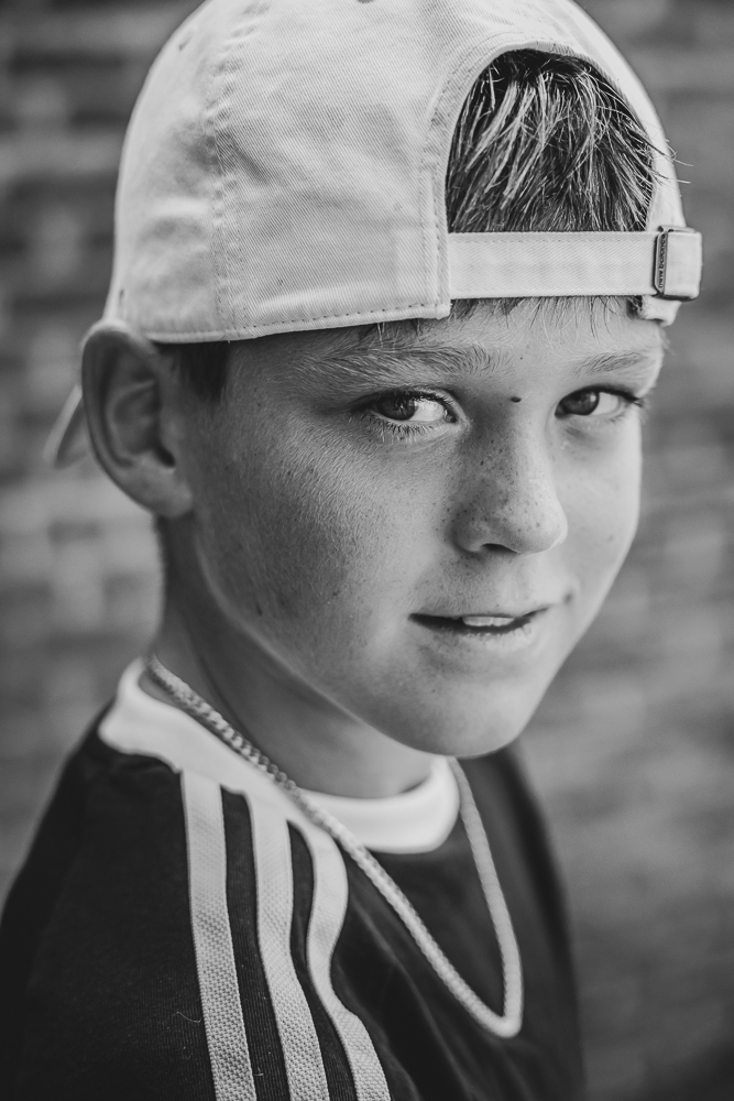 Fotograaf Dokkum. Zwart-wit portret van jongen met pet door Nickie Fotografie.