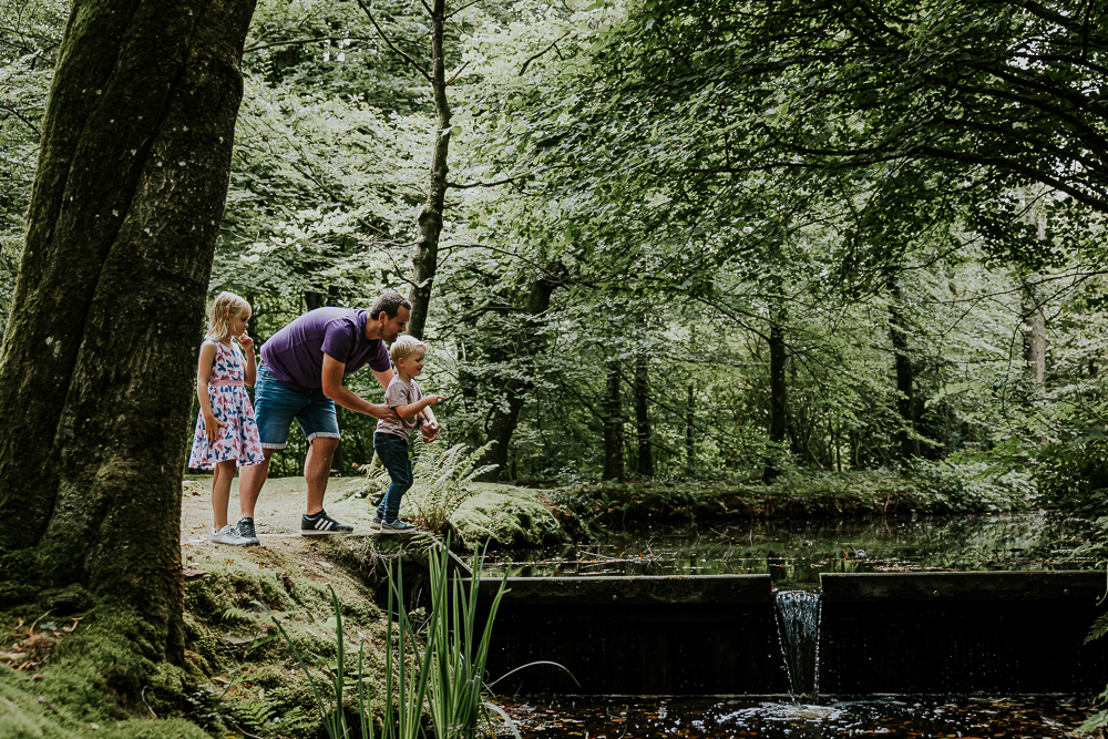 Stenen en takken gooien in het water. Gezinsreportage door fotograaf Nickie Fotografie uit Friesland.