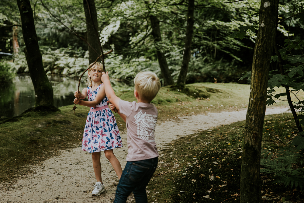 Lifestyle fotoshoot bij Park Vijversburg in Tytsjerk. Broer en zus spelen met de takken. Fotoreportage door fotograaf Nickie Fotografie.