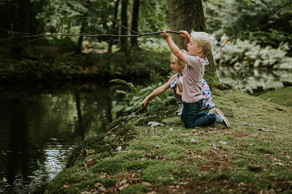 Fotoshoot Friesland. De kinderen zijn aan het vissen met takken. Gezinsshoot door fotograaf Nickie Fotografie uit Friesland.