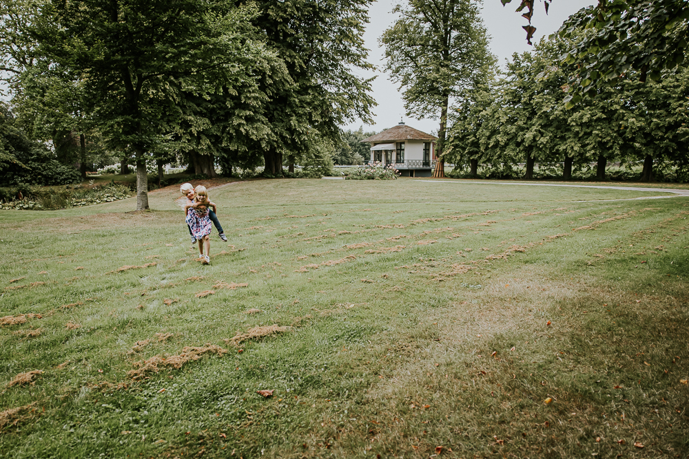 Lifestyle gezinsshoot bij park Vijversburg. De kinderen rennen over het grasveld. Fotoshoot door fotograaf Nickie Fotografie uit Friesland.