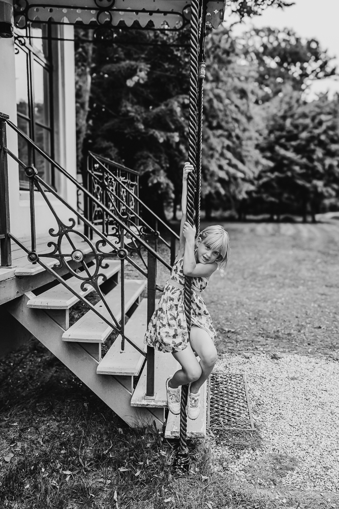 Lifestyle gezinsshoot. Meisje hangt aan de trap bij de theekoepel van Park Vijversburg/bos van Ypey. Gezinsreportage door fotograaf Nickie Fotografie.