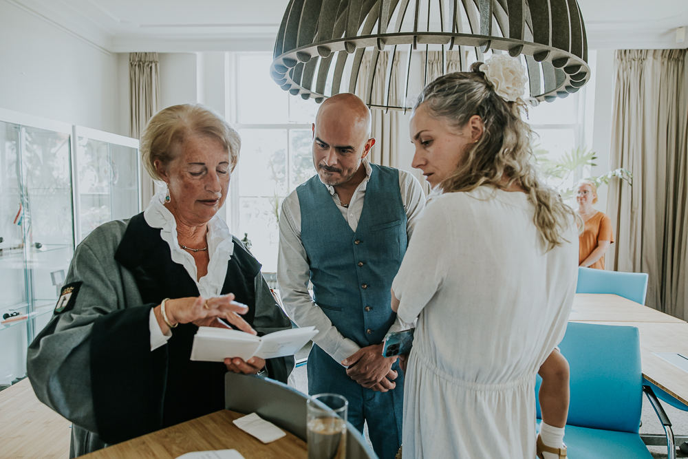 De trouwambtenaar/babs overhandigt het trouwboekje aan het bruidspaar. Trouwfotografie door huwelijksfotograaf Nickie Fotografie uit Friesland.
