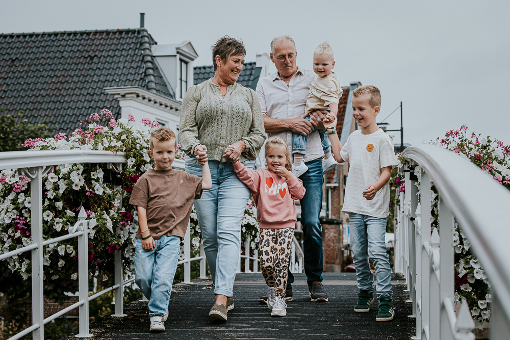 Fotograaf Friesland. Pake en Beppe lopen met alle kleinkinderen over het witte bruggetje in Dokkum. Familieshoot door Nickie Fotografie.