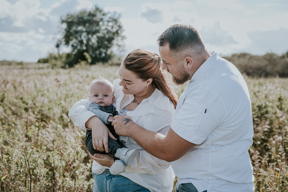 Gezinshoot Lauwersmeer. Portret van het jonge gezin bij een rietveld door fotograaf Nickie Fotografie uit Friesland.