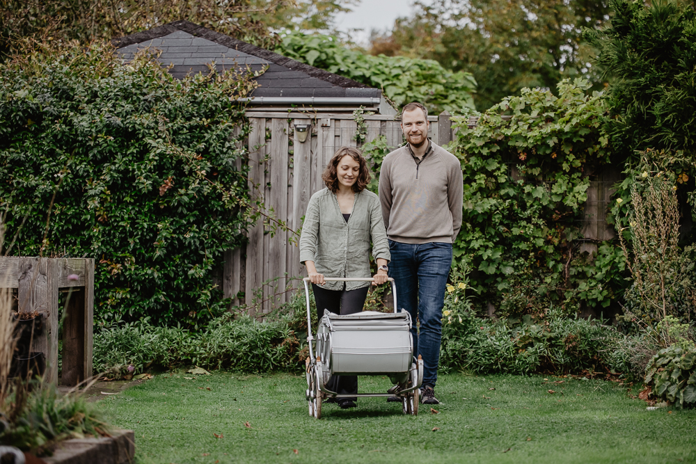 Lifestyle babyfotografie. De kersverse ouders aan de wandel met hun baby in de antieke kinderwagen. Fotoshoot door newbornfotograaf Nickie Fotografie uit Friesland.
