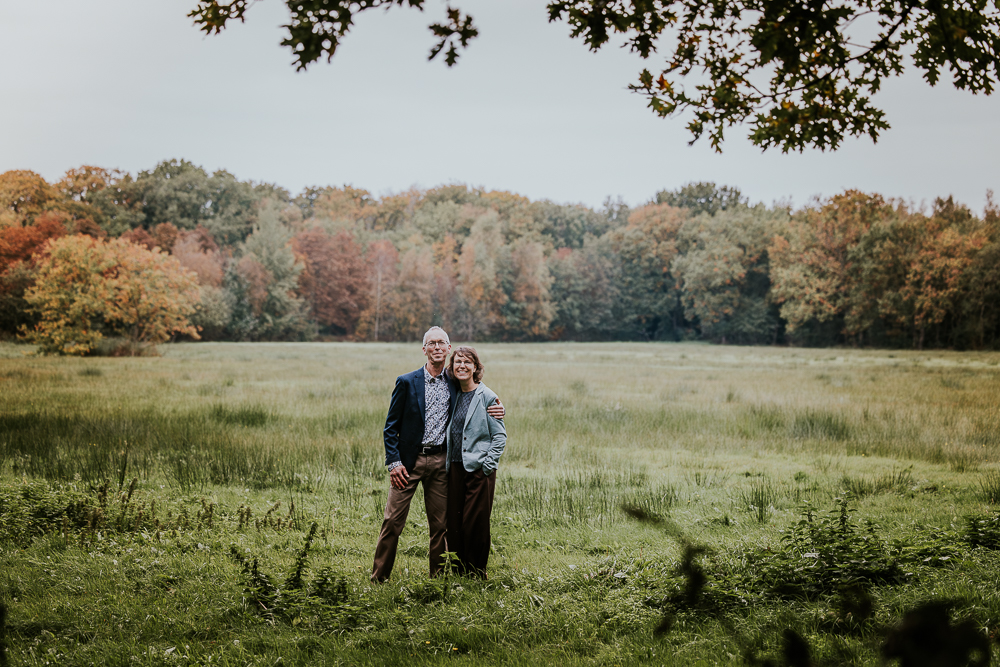 Herfstshoot Friesland. Portret in open veld met prachtige kleuren in de achtergrond door fotograaf Nickie Fotografie.
