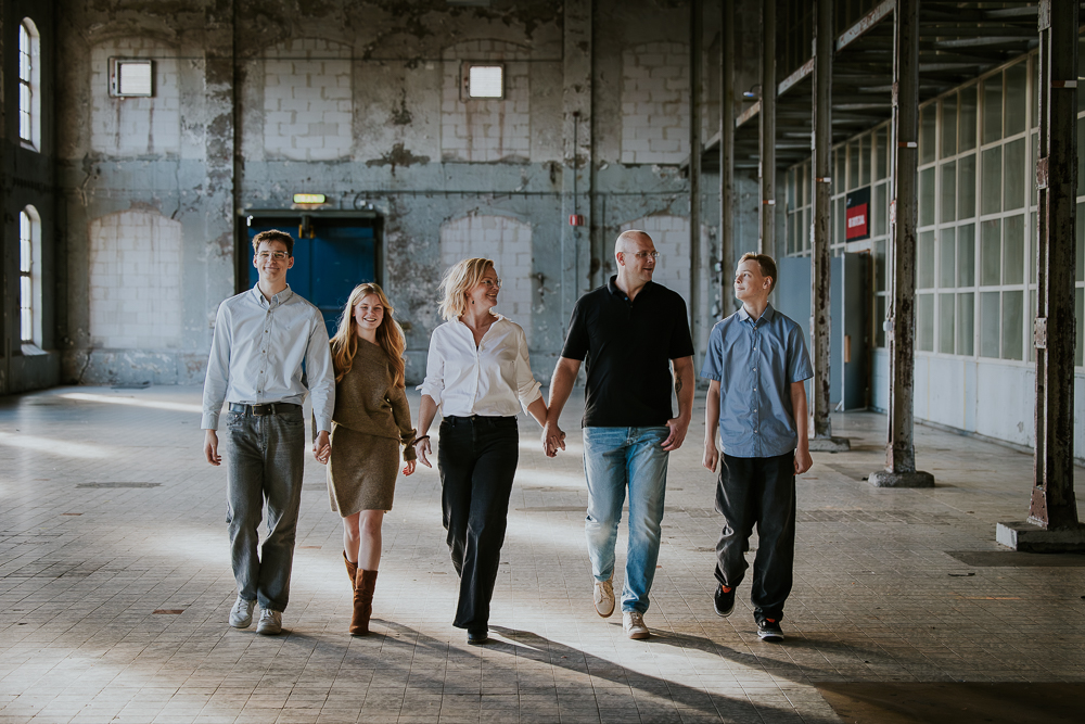 Familieshoot in de oude Suikerfabriek te Groningen. Het gezin loopt door de balzaal. Fotoshoot door fotograaf Nickie Fotografie.