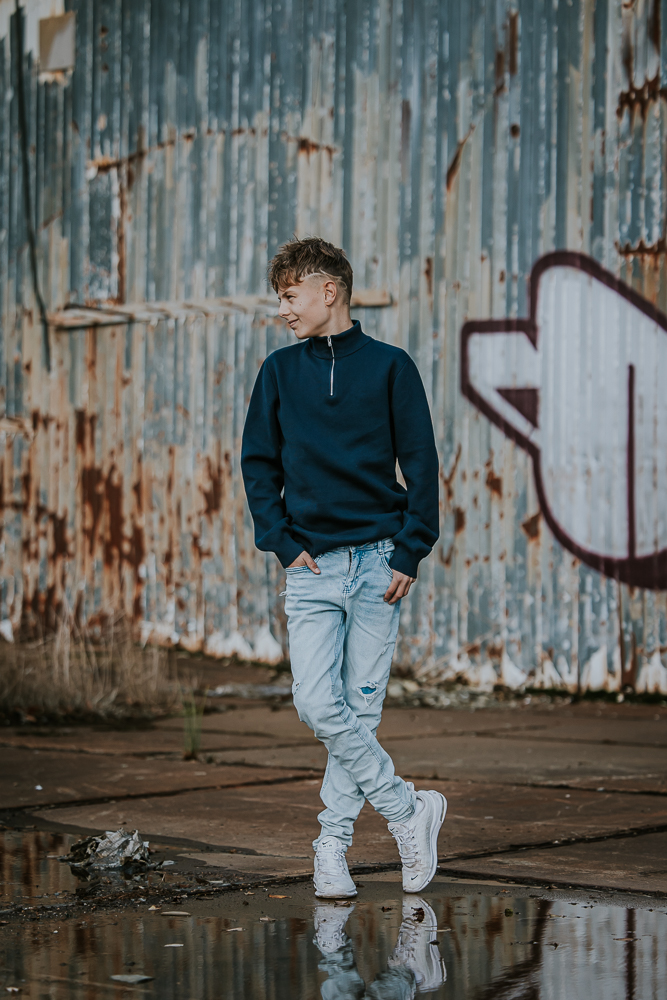 Fotoshoot Friesland. Portret van jongen voor golfplaten graffiti muur door fotograaf Nickie Fotografie uit Dokkum.