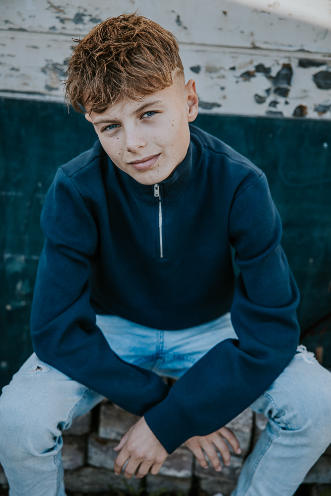 Portret van zittende jongen kijkend in de camera. Fotoshoot Friesland door fotograaf Nickie Fotografie uit Dokkum.