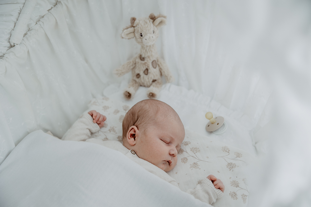 Fotograaf Friesland. Newbornshoot in Feanwâlden door Nickie Fotografie. Baby ligt in zijn wiegje te slapen.