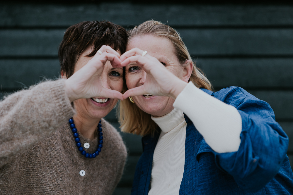 Vriendinnenshoot Friesland. De twee vriendinnen maken samen een hart van hun handen. Fotoshoot door fotograaf Nickie Fotografie uit Dokkum,