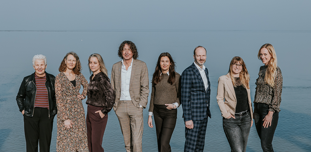 Roos Makelaars Dokkum. Groepsportret bij het Wad door bedrijfsfotograaf Nickie Fotografie.