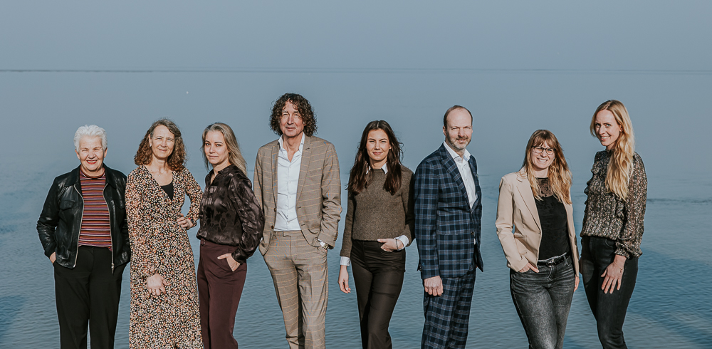 Roos Makelaars Dokkum. Groepsportret bij het Wad door bedrijfsfotograaf Nickie Fotografie.