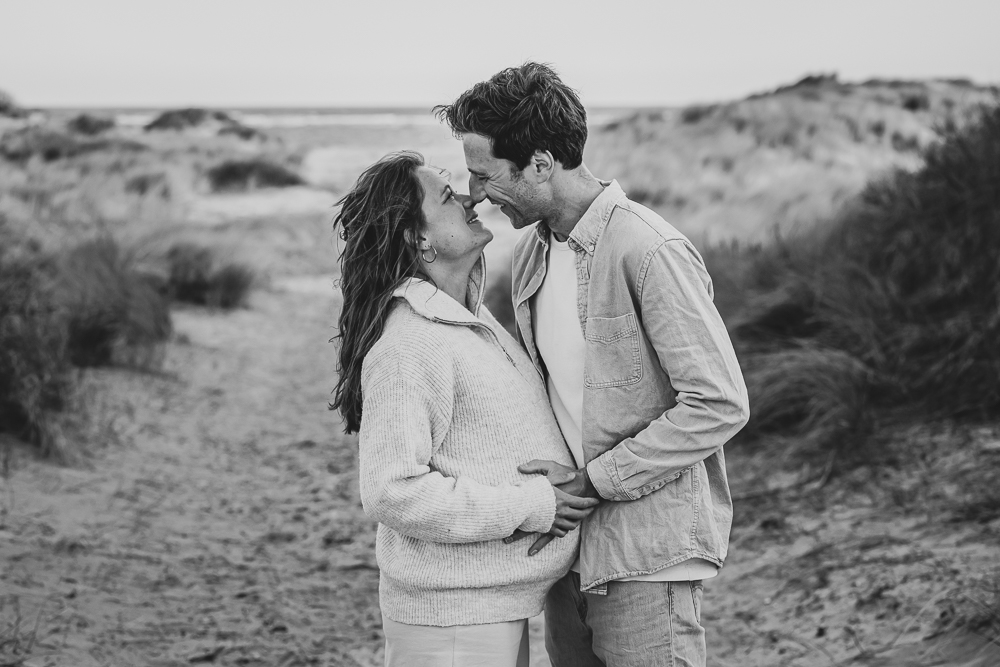 Zwart-wit fotoreportage in de duinen door fotograaf Nickie Fotografie uit Friesland. Liefdevol moment tussen de aanstaande ouders.