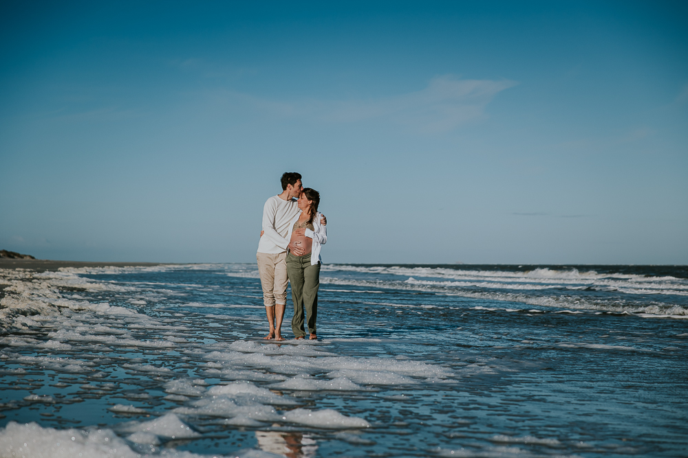 Fotograaf Schiermonnikoog. Zwangerschapsfotografie met partner op Schiermonnikoog door Nickie Fotografie. Romantisch wandelen door de branding op blote voetjes.