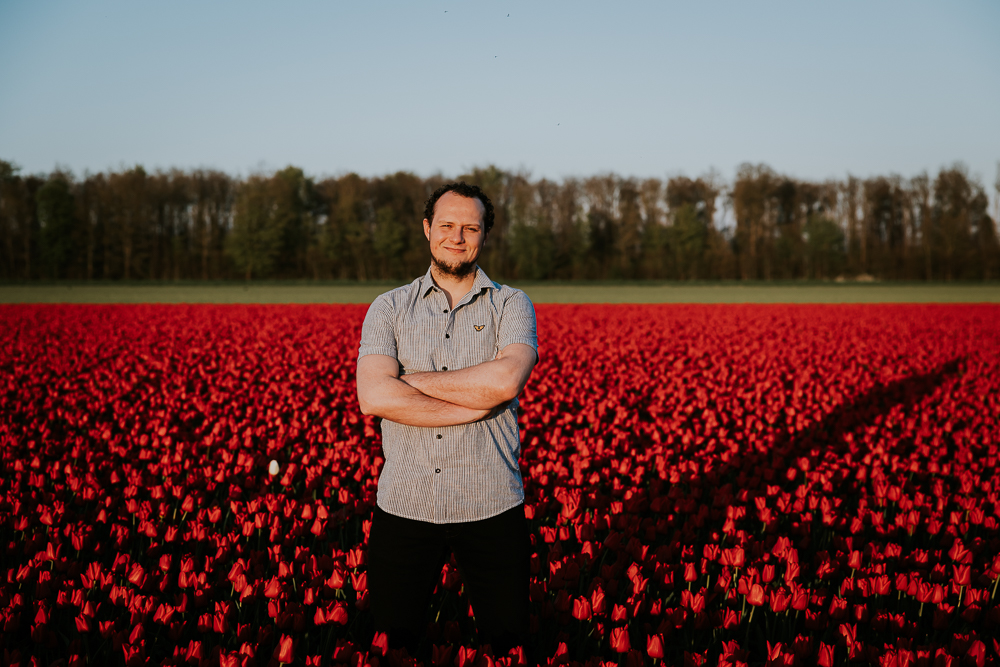 Portret tussen de rode tulpen door fotograaf Nickie Fotografie uit Dokkum, Friesland.