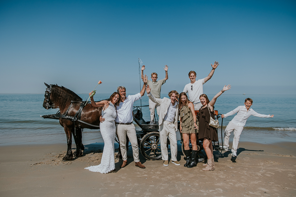 Groepsfoto op bij de koets bij de zee.