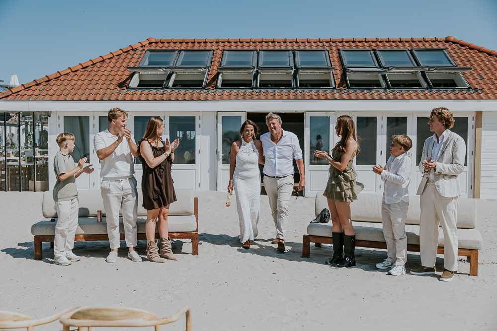De binnenkomst van het bruidspaar bij de trouwceremonie bij Beachclub The Sunset Hollum.