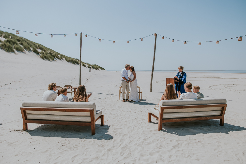 De kus!!! Trouwen op het strand van Ameland bij Beachclub The Sunset te Hollum. Bruidsfotografie door trouwfotograaf Nickie Fotografie uit Friesland.