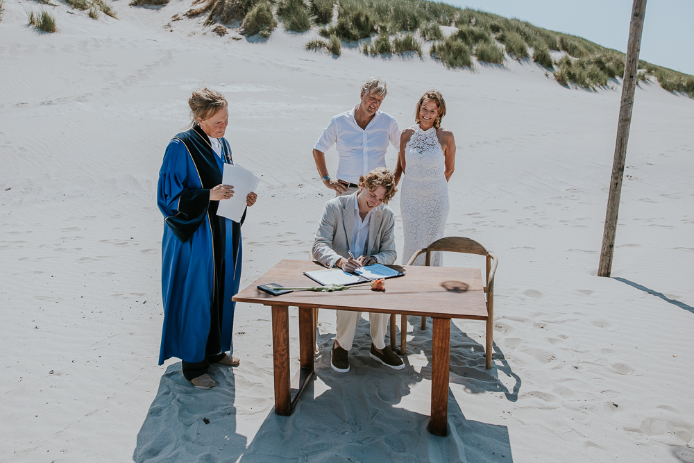 Het ondertekenen van de trouwakte door een getuige. Huwelijksreportage door bruidsfotograaf Nickie Fotografie uit Friesland.