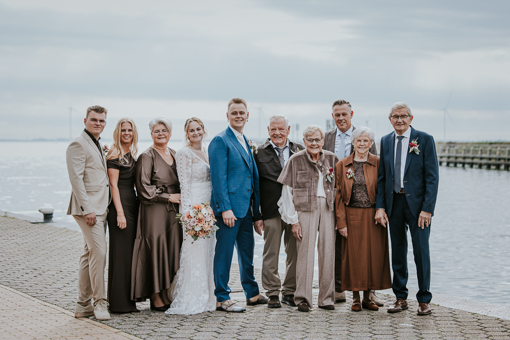 Familiefoto bij  het water tijdens de trouwerij.