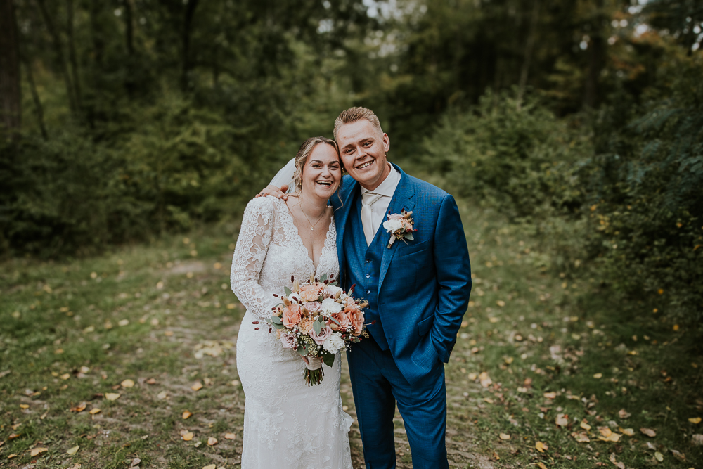 Fotoshoot van het bruidspaar in het bos.